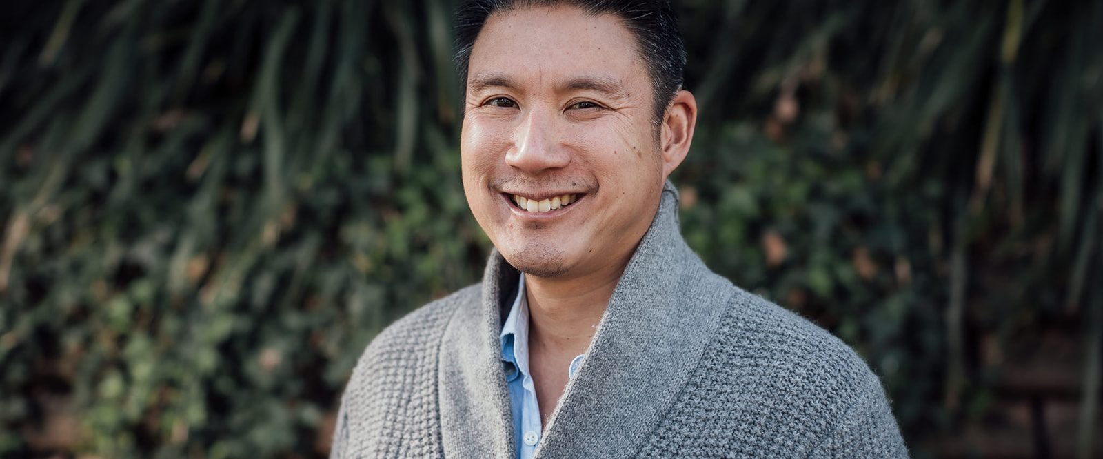 A man with a cochlear implant, smiling at the camera.